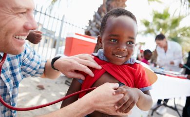 Shot of a volunteer doctor giving checkups to underprivileged kids.